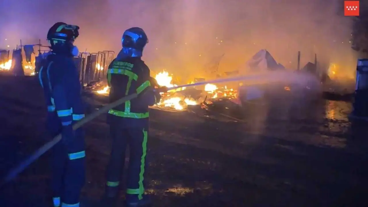 Dos bomberos de la Comunidad de Madrid tratan de apagar un incendio en infraviviendas en Legan&eacute;s Norte. Imagen de 112 Comunidad de Madrid.