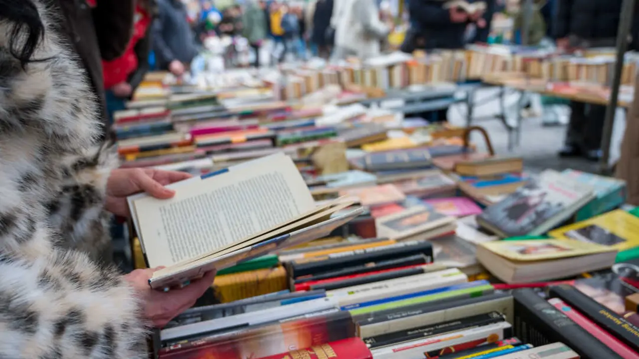 Una mujer mira libros. Imagen de archivo.