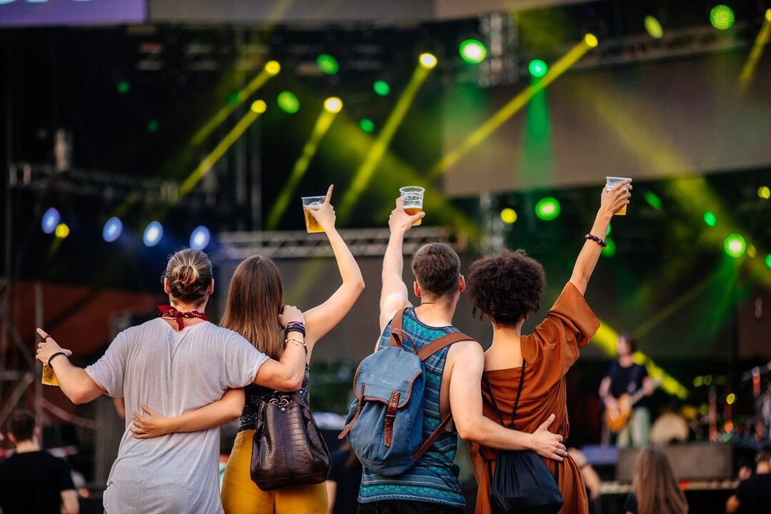 Personas disfrutando de un concierto con cerveza. Imagen de archivo.