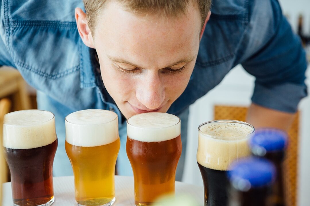 Hombre oliendo cerveza. Imagen de archivo.