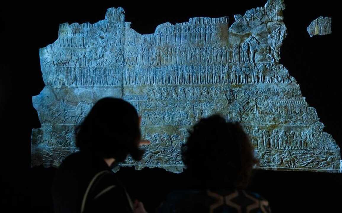 Dos visitantes admiran una de las piezas presentes en la exposición Asurbanipal en CaixaForum Madrid. Imagen de CaixaForum.